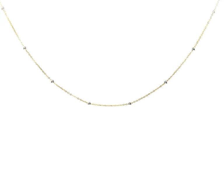 Oro 18k Amarillo, con Bolita de Oro Blanco. Incluye cadena. Largo: 45 cm
